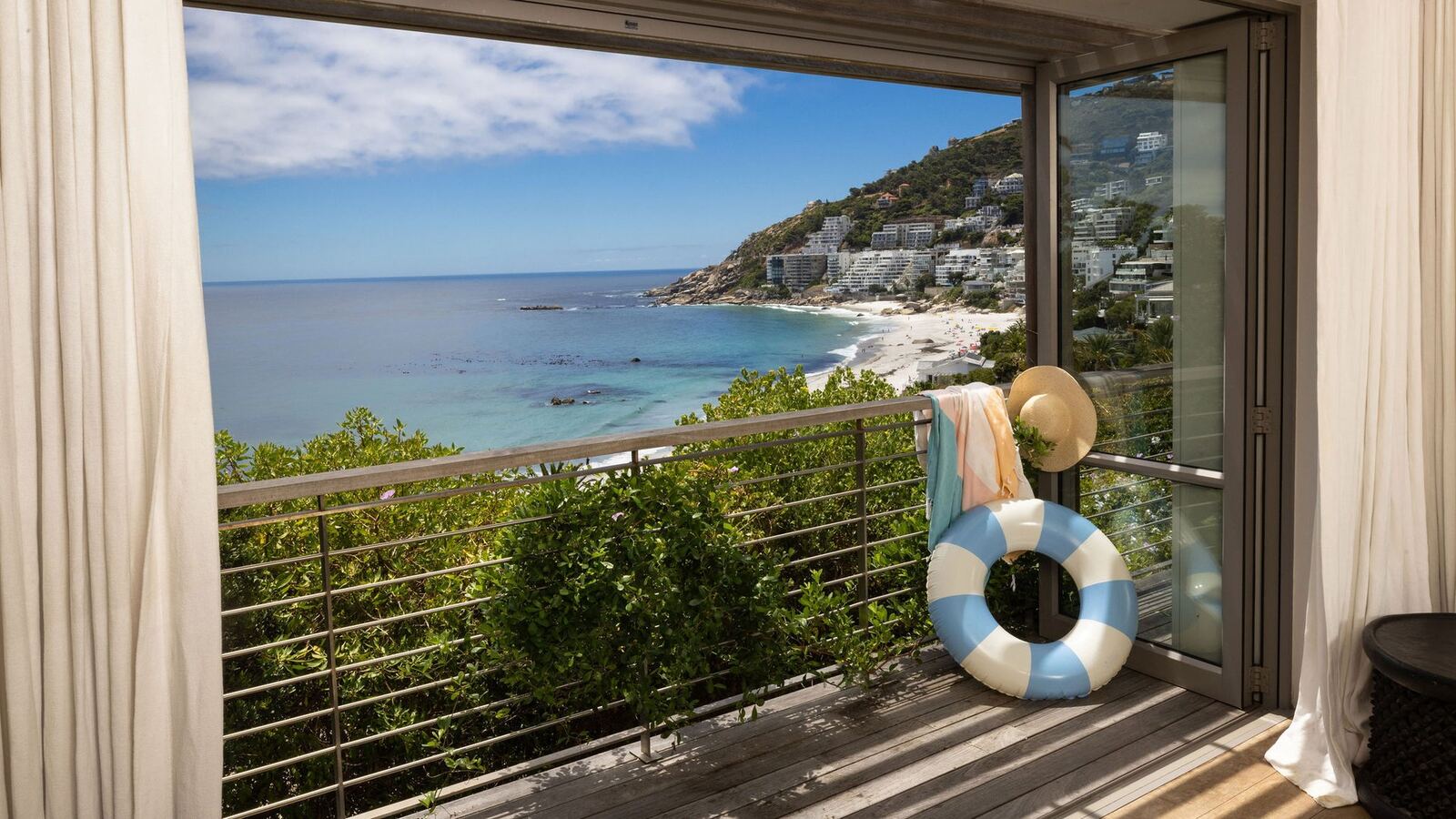 Clifton villa balcony looking over the Atlantic, sunhat and float by the glass doors