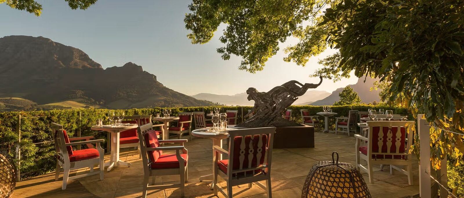 An estate terrace dinner table at dusk with mountains behind